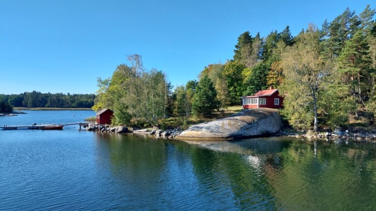 Red Swedish cottage on granite rock facing Stockholm archipelago — building, landform and water in Feng Shui